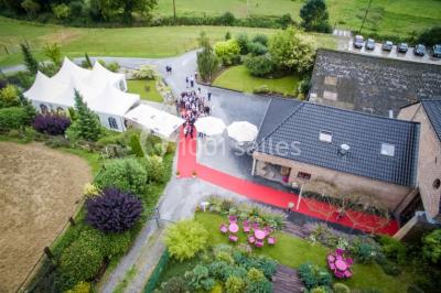 Un couple en tenue de mariage se tient la main dans un jardin baigné par une lumière douce au coucher du soleil.