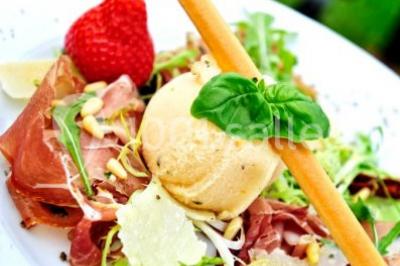 Un couple en tenue de mariage se tient la main dans un jardin baigné par une lumière douce au coucher du soleil.