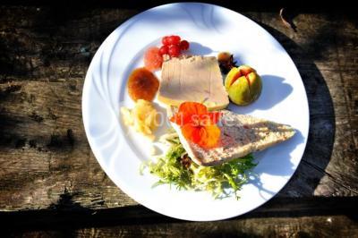 Un couple en tenue de mariage se tient la main dans un jardin baigné par une lumière douce au coucher du soleil.