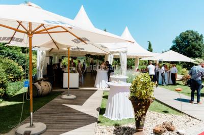 Un couple en tenue de mariage se tient la main dans un jardin baigné par une lumière douce au coucher du soleil.
