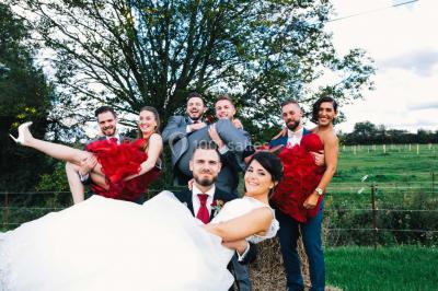 Un couple en tenue de mariage se tient la main dans un jardin baigné par une lumière douce au coucher du soleil.
