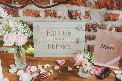 Un couple en tenue de mariage se tient la main dans un jardin baigné par une lumière douce au coucher du soleil.