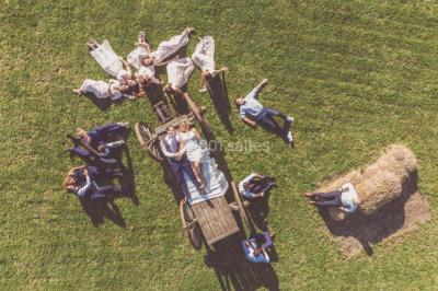 Un couple en tenue de mariage se tient la main dans un jardin baigné par une lumière douce au coucher du soleil.