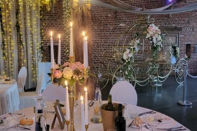 Un couple en tenue de mariage se tient la main dans un jardin baigné par une lumière douce au coucher du soleil.