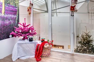 Miniature Location salle Asnières-sur-Seine (Hauts-de-Seine) - Loft C'est Incroyable #44 Table de fête décorée avec vaisselle élégante, sapin de Noël illuminé et cheminée allumée en arrière-plan.