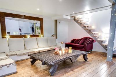 Miniature Location salle Asnières-sur-Seine (Hauts-de-Seine) - Loft C'est Incroyable #2 Table de fête décorée avec vaisselle élégante, sapin de Noël illuminé et cheminée allumée en arrière-plan.