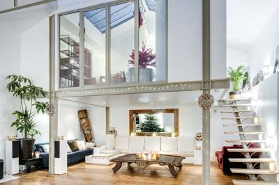 Miniature Location salle Asnières-sur-Seine (Hauts-de-Seine) - Loft C'est Incroyable #32 Table de fête décorée avec vaisselle élégante, sapin de Noël illuminé et cheminée allumée en arrière-plan.