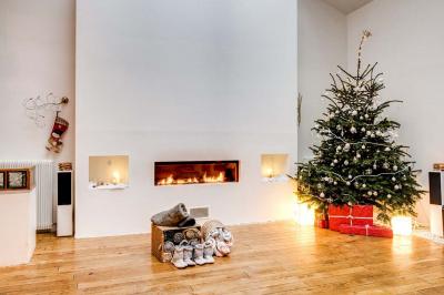 Miniature Location salle Asnières-sur-Seine (Hauts-de-Seine) - Loft C'est Incroyable #35 Table de fête décorée avec vaisselle élégante, sapin de Noël illuminé et cheminée allumée en arrière-plan.