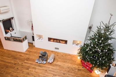 Miniature Location salle Asnières-sur-Seine (Hauts-de-Seine) - Loft C'est Incroyable #23 Table de fête décorée avec vaisselle élégante, sapin de Noël illuminé et cheminée allumée en arrière-plan.