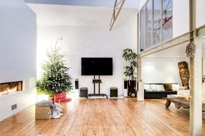 Miniature Location salle Asnières-sur-Seine (Hauts-de-Seine) - Loft C'est Incroyable #27 Table de fête décorée avec vaisselle élégante, sapin de Noël illuminé et cheminée allumée en arrière-plan.