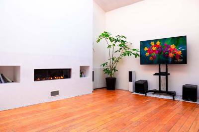 Miniature Location salle Asnières-sur-Seine (Hauts-de-Seine) - Loft C'est Incroyable #34 Table de fête décorée avec vaisselle élégante, sapin de Noël illuminé et cheminée allumée en arrière-plan.