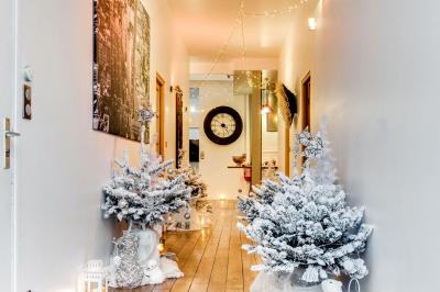 Miniature Location salle Asnières-sur-Seine (Hauts-de-Seine) - Loft C'est Incroyable #48 Table de fête décorée avec vaisselle élégante, sapin de Noël illuminé et cheminée allumée en arrière-plan.