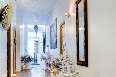 Miniature Location salle Asnières-sur-Seine (Hauts-de-Seine) - Loft C'est Incroyable #52 Table de fête décorée avec vaisselle élégante, sapin de Noël illuminé et cheminée allumée en arrière-plan.