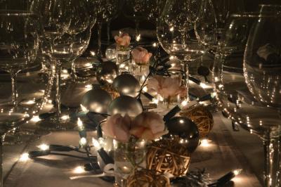 Miniature Location salle Asnières-sur-Seine (Hauts-de-Seine) - Loft C'est Incroyable #51 Table de fête décorée avec vaisselle élégante, sapin de Noël illuminé et cheminée allumée en arrière-plan.