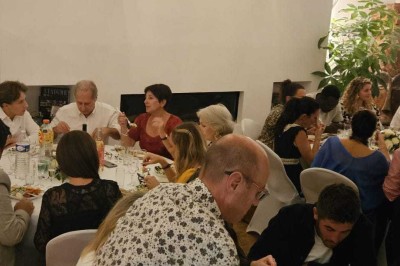 Miniature Location salle Asnières-sur-Seine (Hauts-de-Seine) - Loft C'est Incroyable #56 Table de fête décorée avec vaisselle élégante, sapin de Noël illuminé et cheminée allumée en arrière-plan.