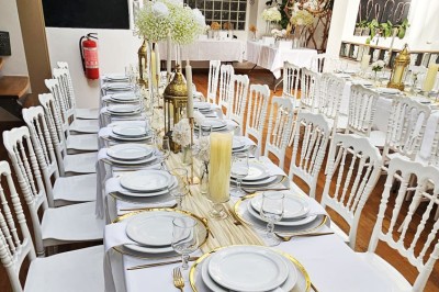 Miniature Location salle Asnières-sur-Seine (Hauts-de-Seine) - Loft C'est Incroyable #16 Table de fête décorée avec vaisselle élégante, sapin de Noël illuminé et cheminée allumée en arrière-plan.