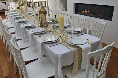 Miniature Location salle Asnières-sur-Seine (Hauts-de-Seine) - Loft C'est Incroyable #19 Table de fête décorée avec vaisselle élégante, sapin de Noël illuminé et cheminée allumée en arrière-plan.