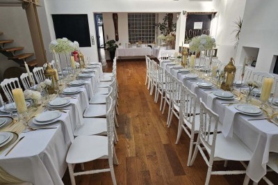 Miniature Location salle Asnières-sur-Seine (Hauts-de-Seine) - Loft C'est Incroyable #17 Table de fête décorée avec vaisselle élégante, sapin de Noël illuminé et cheminée allumée en arrière-plan.