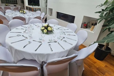 Miniature Location salle Asnières-sur-Seine (Hauts-de-Seine) - Loft C'est Incroyable #9 Table de fête décorée avec vaisselle élégante, sapin de Noël illuminé et cheminée allumée en arrière-plan.