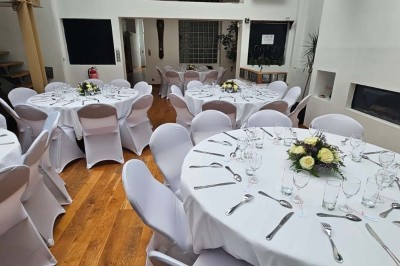 Miniature Location salle Asnières-sur-Seine (Hauts-de-Seine) - Loft C'est Incroyable #8 Table de fête décorée avec vaisselle élégante, sapin de Noël illuminé et cheminée allumée en arrière-plan.