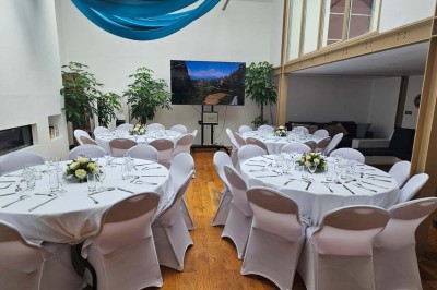 Miniature Location salle Asnières-sur-Seine (Hauts-de-Seine) - Loft C'est Incroyable #7 Table de fête décorée avec vaisselle élégante, sapin de Noël illuminé et cheminée allumée en arrière-plan.