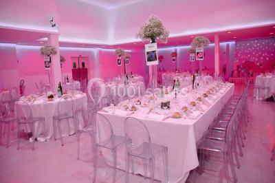 Miniature Location salle Montmorency (Val-d'Oise) - Le Concept Réception #3 Mains d'un couple portant des alliances, posées sur un bouquet de fleurs blanches et violettes.