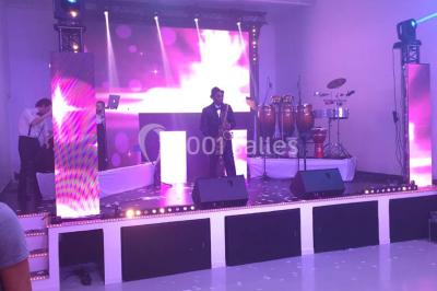 Miniature Location salle Montmorency (Val-d'Oise) - Le Concept Réception #5 Mains d'un couple portant des alliances, posées sur un bouquet de fleurs blanches et violettes.