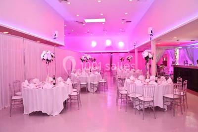 Miniature Location salle Montmorency (Val-d'Oise) - Le Concept Réception #2 Mains d'un couple portant des alliances, posées sur un bouquet de fleurs blanches et violettes.