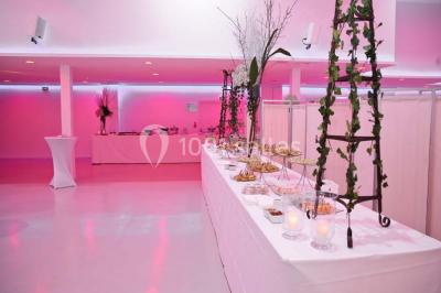 Miniature Location salle Montmorency (Val-d'Oise) - Le Concept Réception #10 Mains d'un couple portant des alliances, posées sur un bouquet de fleurs blanches et violettes.