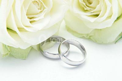 Miniature Location salle Montmorency (Val-d'Oise) - Le Concept Réception #11 Mains d'un couple portant des alliances, posées sur un bouquet de fleurs blanches et violettes.