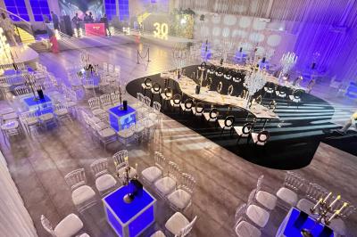 Miniature Location salle Saint-Germain-lès-Arpajon (Essonne) - Voilier 91 #6 Voiture de sport verte aux portes papillon ouvertes, entourée de fumée et d'une foule dans un lieu éclairé.