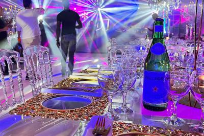 Miniature Location salle Saint-Germain-lès-Arpajon (Essonne) - Voilier 91 #7 Voiture de sport verte aux portes papillon ouvertes, entourée de fumée et d'une foule dans un lieu éclairé.