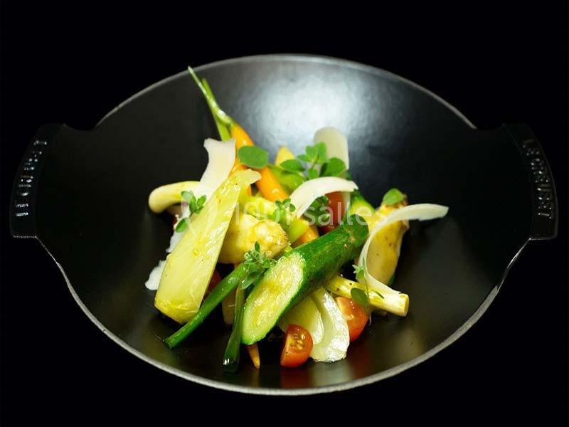Légumes variés cuits à la vapeur présentés dans un wok noir sur fond sombre.