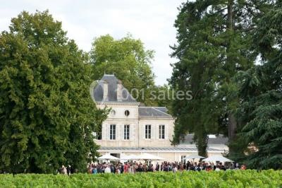 Inscription ’NOUCHET’ gravée sur une façade en pierre et briques, entourée de végétation en arrière-plan.