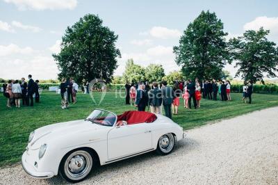 Inscription ’NOUCHET’ gravée sur une façade en pierre et briques, entourée de végétation en arrière-plan.