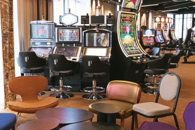 Miniature Location salle Cabourg (Calvados) - Casino de Cabourg #1 Menu posé sur une table ronde dans un bar élégant avec un comptoir éclairé en arrière-plan.