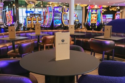 Miniature Bar Menu posé sur une table ronde dans un bar élégant avec un comptoir éclairé en arrière-plan.