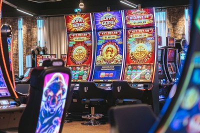 Miniature Machines à sous Menu posé sur une table ronde dans un bar élégant avec un comptoir éclairé en arrière-plan.