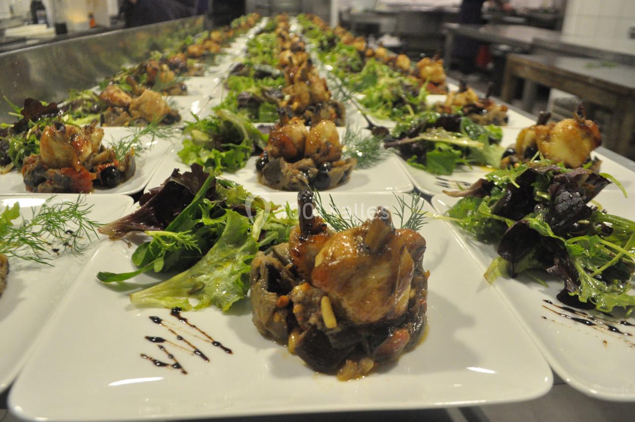 Location salle Crosne (Essonne) - Aux Tulipes #10 Assiettes dressées avec des légumes, salades et morceaux de viande, alignées dans une cuisine professionnelle.