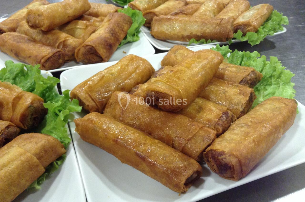 Location salle Crosne (Essonne) - Aux Tulipes #8 Assiettes remplies de nems dorés disposés sur des feuilles de salade verte.