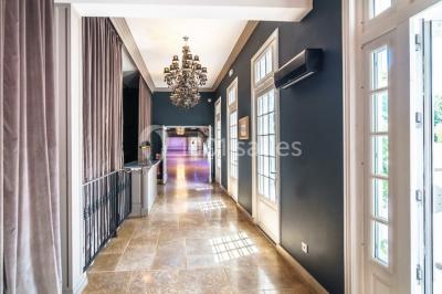 Pont éclairé et kiosque en bois près d'une fontaine illuminée, entourés d'arbres dans un parc nocturne.
