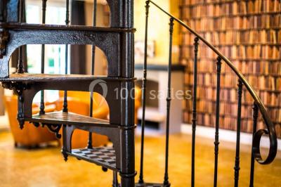 Pont éclairé et kiosque en bois près d'une fontaine illuminée, entourés d'arbres dans un parc nocturne.