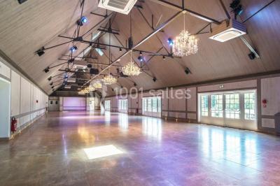 Pont éclairé et kiosque en bois près d'une fontaine illuminée, entourés d'arbres dans un parc nocturne.