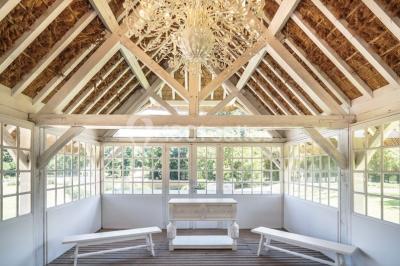 Pont éclairé et kiosque en bois près d'une fontaine illuminée, entourés d'arbres dans un parc nocturne.
