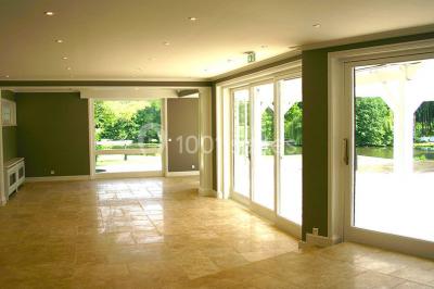 Pont éclairé et kiosque en bois près d'une fontaine illuminée, entourés d'arbres dans un parc nocturne.