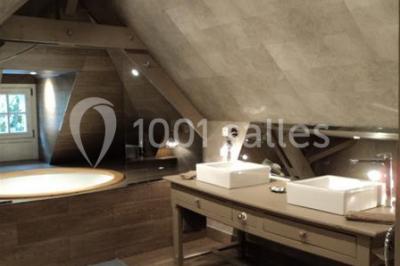 Pont éclairé et kiosque en bois près d'une fontaine illuminée, entourés d'arbres dans un parc nocturne.