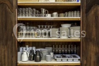 Miniature Location salle Plaisir (Yvelines) - La Ferme du Buisson #24 Armoire en bois ouverte contenant des verres, assiettes, bols, carafes et paniers soigneusement rangés sur des étagères.