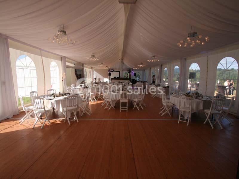 Location salle Meyrignac-l'Église (Corrèze) - Domaine des Monédières #3 Intérieur d'une tente de réception avec tables rondes dressées, chaises blanches et plafond drapé de tissu blanc.