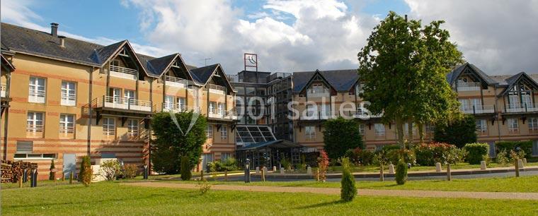 Bâtiment à l'architecture moderne avec façades en briques et toits en ardoise, entouré d'espaces verts.