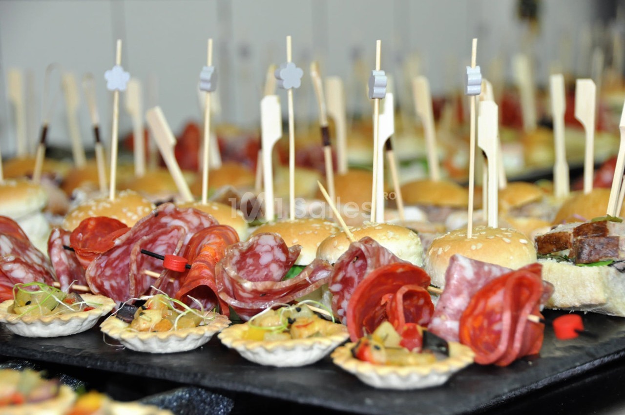 Plateau de bouchées apéritives variées avec mini-burgers, charcuterie et tartelettes garnies.